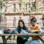 multiethnic students reading information on paper